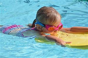 Little Girl Swimming With Her Body Board